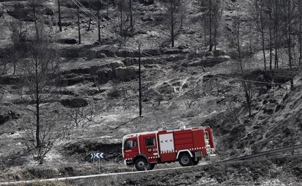 A fire engine passes through an area devastated by the flames in the town of El Pont de Vilomara