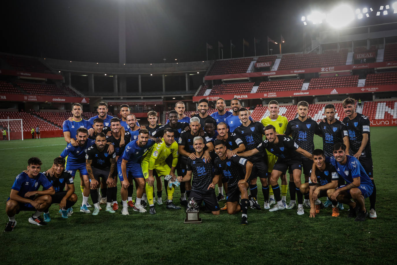 The Malaga squad pose with the Trofeo Ciudad de Granada. 