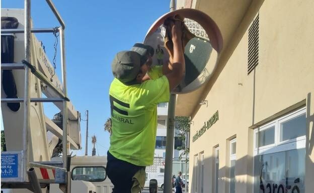 A worker cleaning one of the street signs 