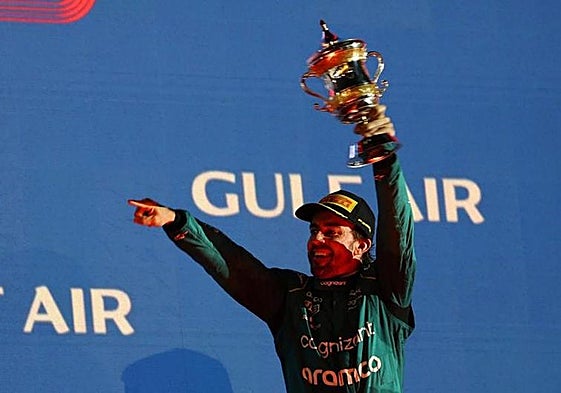 Alonso, 41, lifts his trophy on the podium.