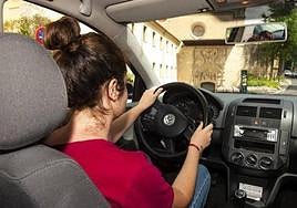 A woman drives a vehicle through the streets of Segovia.