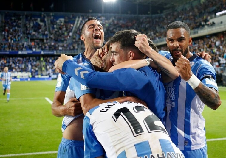 The Malaga players celebrate the winning goal on Monday night.