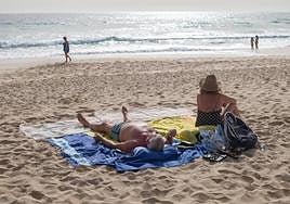 File photograph of people sunbathing on a beach.