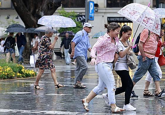 File image of people braving the rain in Malaga centre recently.