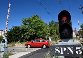 A car crosses a level crossing with barriers.