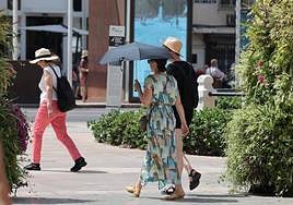 Tourists protect themselves from the sun with an umbrella in Malaga on Sunday.
