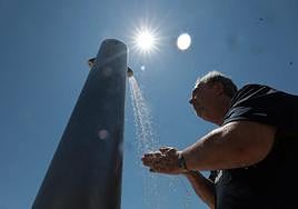 A man cools off at a beach shower in Malaga.