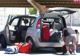 A tourist puts their luggage in a hire car after arriving at Malaga Airport.