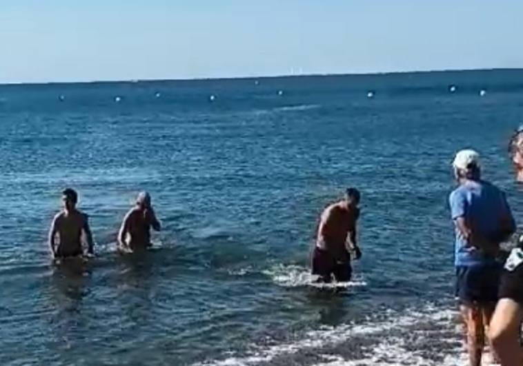The moment the exhausted man arrived back at the shore after being rescued by two police officers.