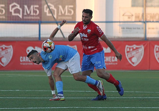Torre del Mar's Arturo fights for the ball.