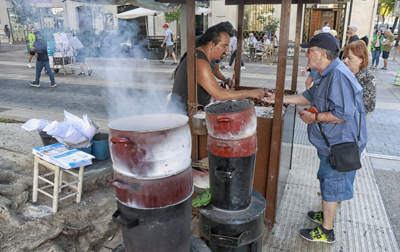 Carlos Santiago serves a customer at his stall in Malaga city centre.