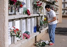 A man places flowers for his loved ones at San Gabriel Cemetery.