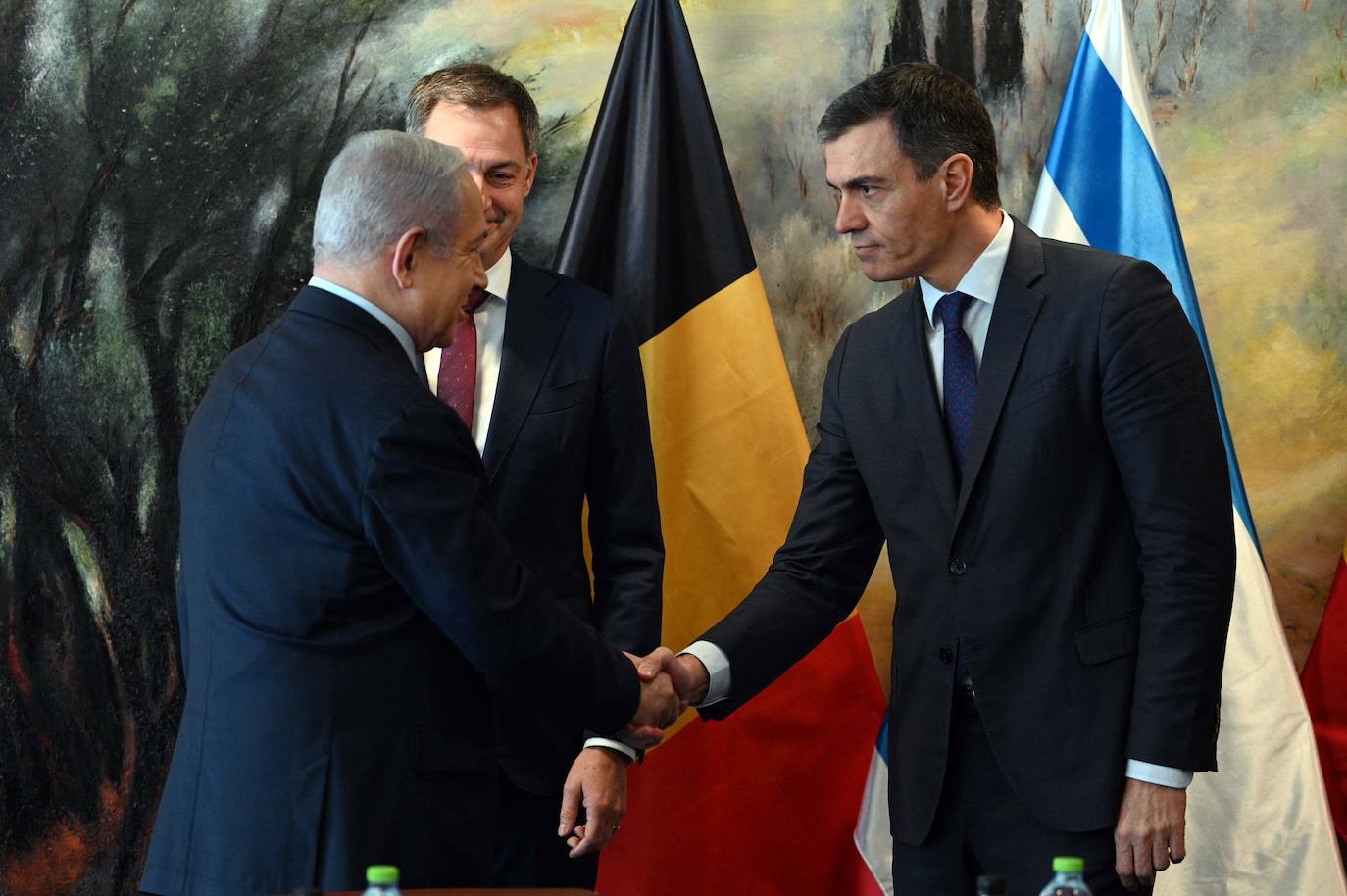 Israeli Prime Minister Benjamin Netanyahu (L) shakes hands with Spain's Prime Minister Pedro Sanchez (R) next to Belgium's Prime Minister Alexander De Croo.