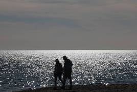Two people walking in Malaga wearing summer clothes.