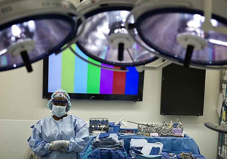 A healthcare worker prepares surgical equipment for a transplant.