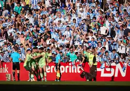 Malaga and their travelling fans celebrate Dioni's goal.