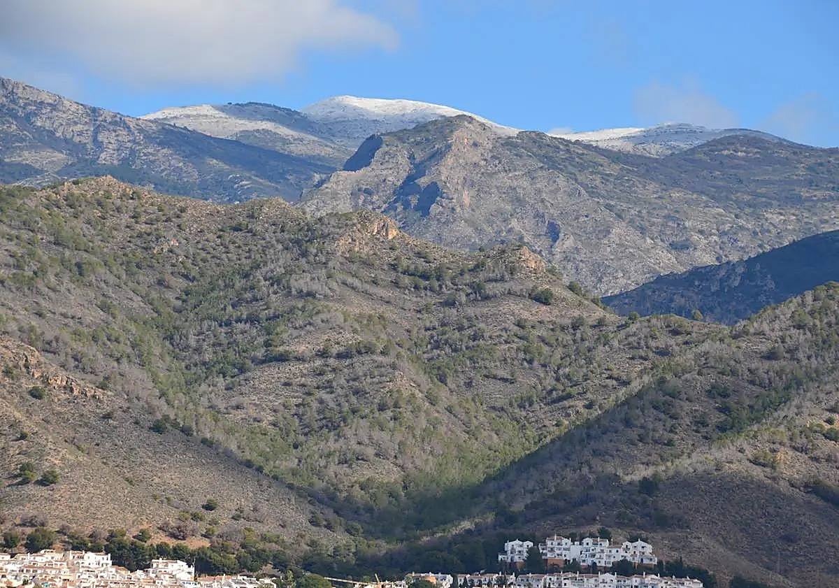 Imagen principal - Snow on the Axarquía mountains and a rainbow over Nerja on Tuesday 27 February.