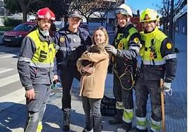 Andrea poses with Coco and the firemen who found the missing pet.