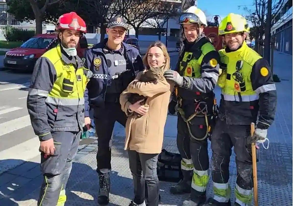 Andrea poses with Coco and the firemen who found the missing pet.
