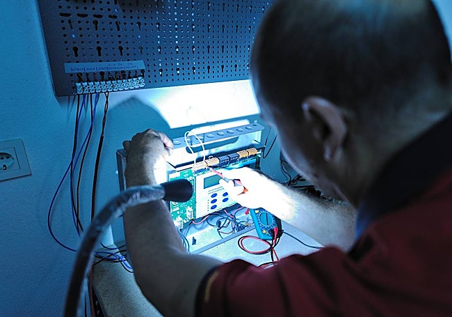A technician checks an alarm system.