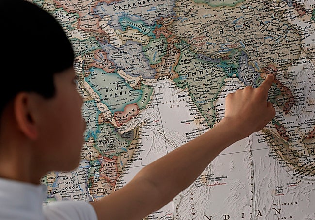 Noah points out on the map the city of Hanoi, his birthplace.