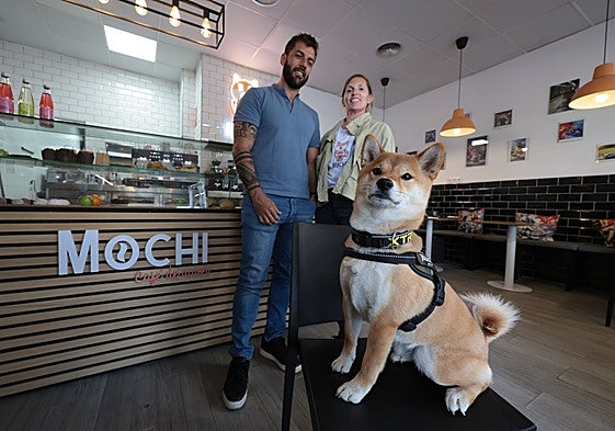 Mochi poses inside the Teatinos shop in front of its owners.