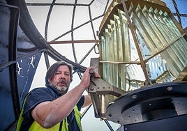Jorge Lacuesta, a technician with Spain's navigation aid service, poses with the lighthouse lantern.