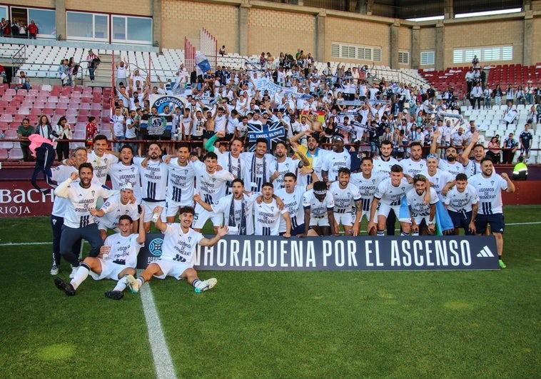 Marbella players celebrate their promotion with the travelling fans.