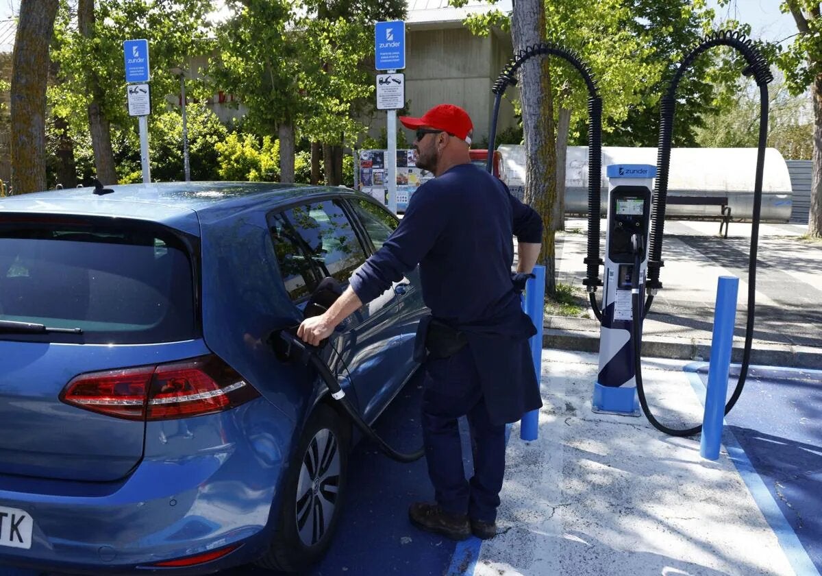 A driver recharges his car at a charging station.