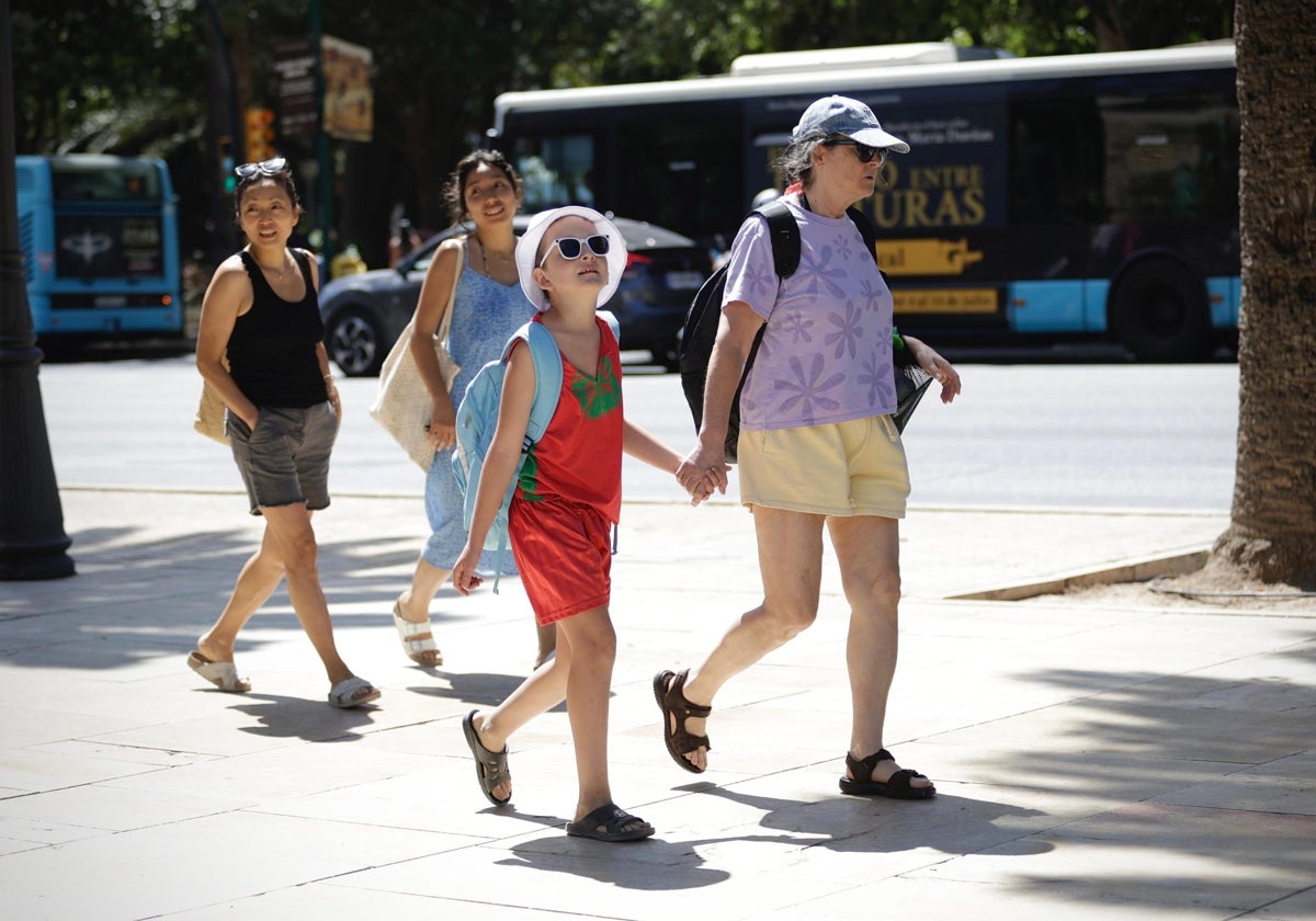 Tourists walk along the Paseo del Parque in Malaga.