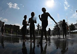 Children cool off in a fountain during a heatwave.