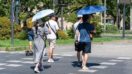 File image of people walking in the streets of Seville next to a thermometer showing 47C.