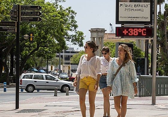 File image of people strolling through the Plaza de la Marina in Malaga with a street thermometer showing a temperature of 38C.