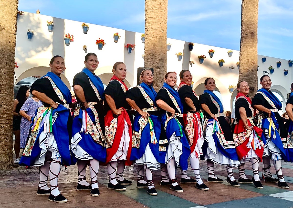Imagen secundaria 1 - Miguel de Miguel receiving his award; dancers on the Balcón de Europa; a tourist receives a white carnation.