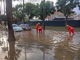 Firefighters work in a flooded area of Benalmádena.
