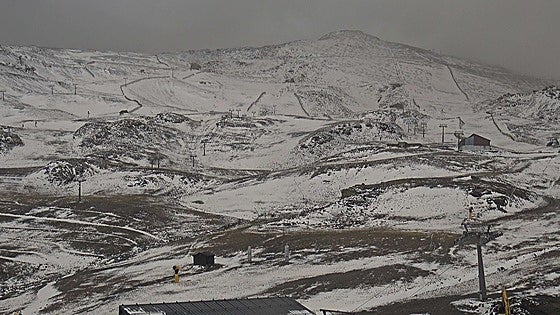 Why is the snow a shade of brown in Spain's normally pristine Sierra Nevada ski resort?