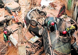 Guardia Civil officers inspect cars while looking for victims swept away in the torrent.