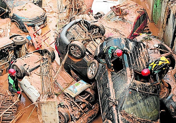 Guardia Civil officers inspect cars while looking for victims swept away in the torrent.