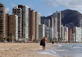 A person walks along the beach in Benidorm
