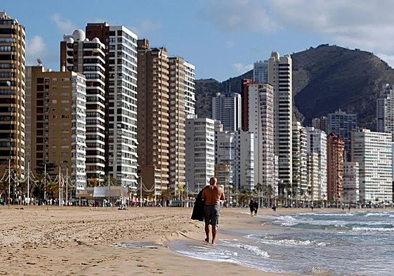 A person walks along the beach in Benidorm