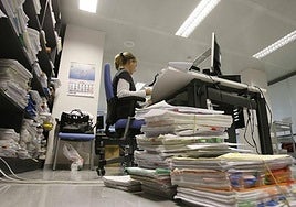 Archive image of a pile of files on the floor next to the desk of an official in the Malaga courts