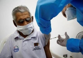 An elderly man receives a Covid vaccine jab during the first phase of vaccinations in Spain.