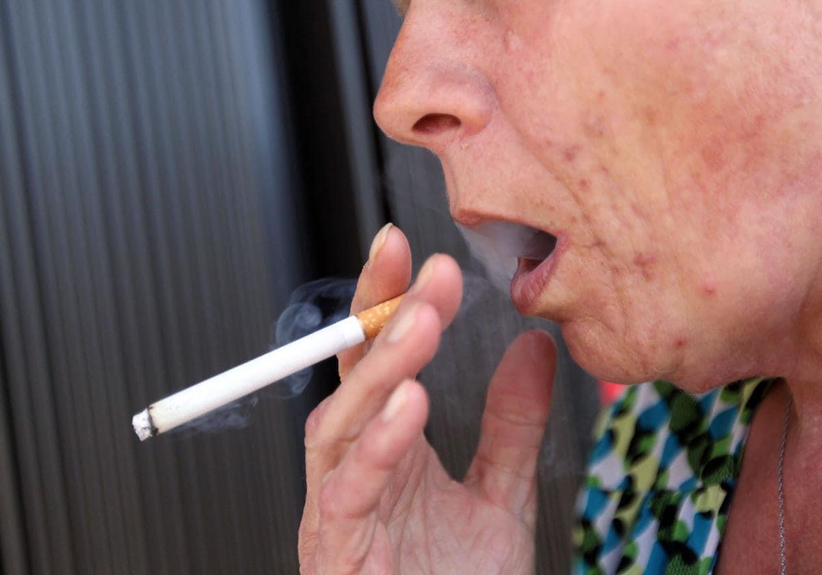 A woman smokes a cigarette.