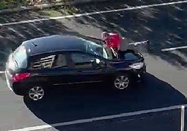Capture of the video showing Juan Iglesias on the bonnet of the car.