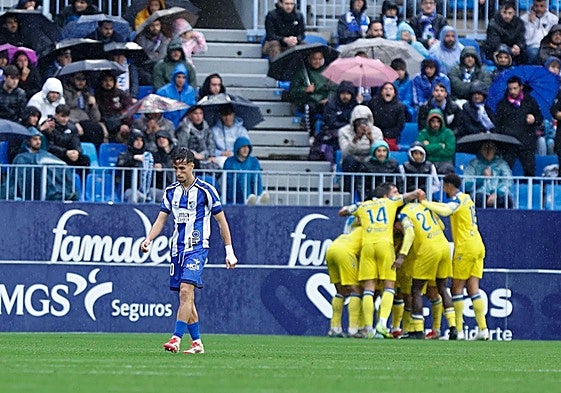 A dejected David Larrubia walks away as the Cadiz players celebrate.