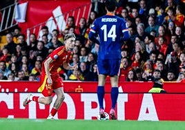 Huijsen progresses with the ball under pressure from Reijnders.