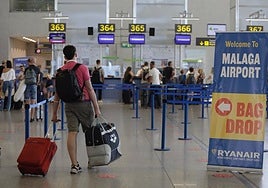Passenger walks towards a Ryanair check-in desk at Malaga Airport.