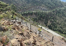 Specialist workers undertaking necessary repairs high above the road to the Costa del Sol closed by storm damage in Malaga province.