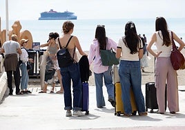 Tourists look out over the sea as their holiday on the Costa del Sol comes to an end.