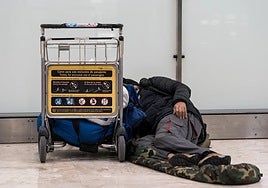 A homeless man sleeps on the floor of Madrid's Barajas airport terminal.